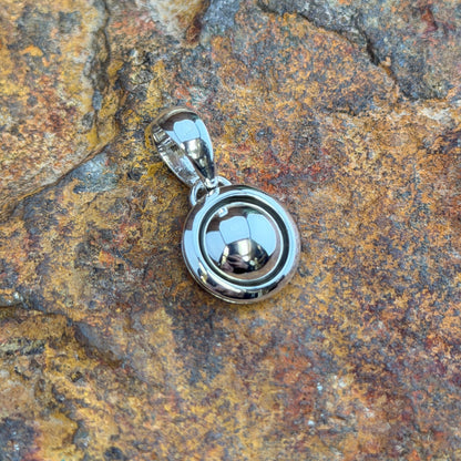  A small Pendant. A polished sterling silver dome sits nestled within a smooth shadowbox rim, creating a clean, sculptural depth in a petite, wearable form. Simple loop bail. 