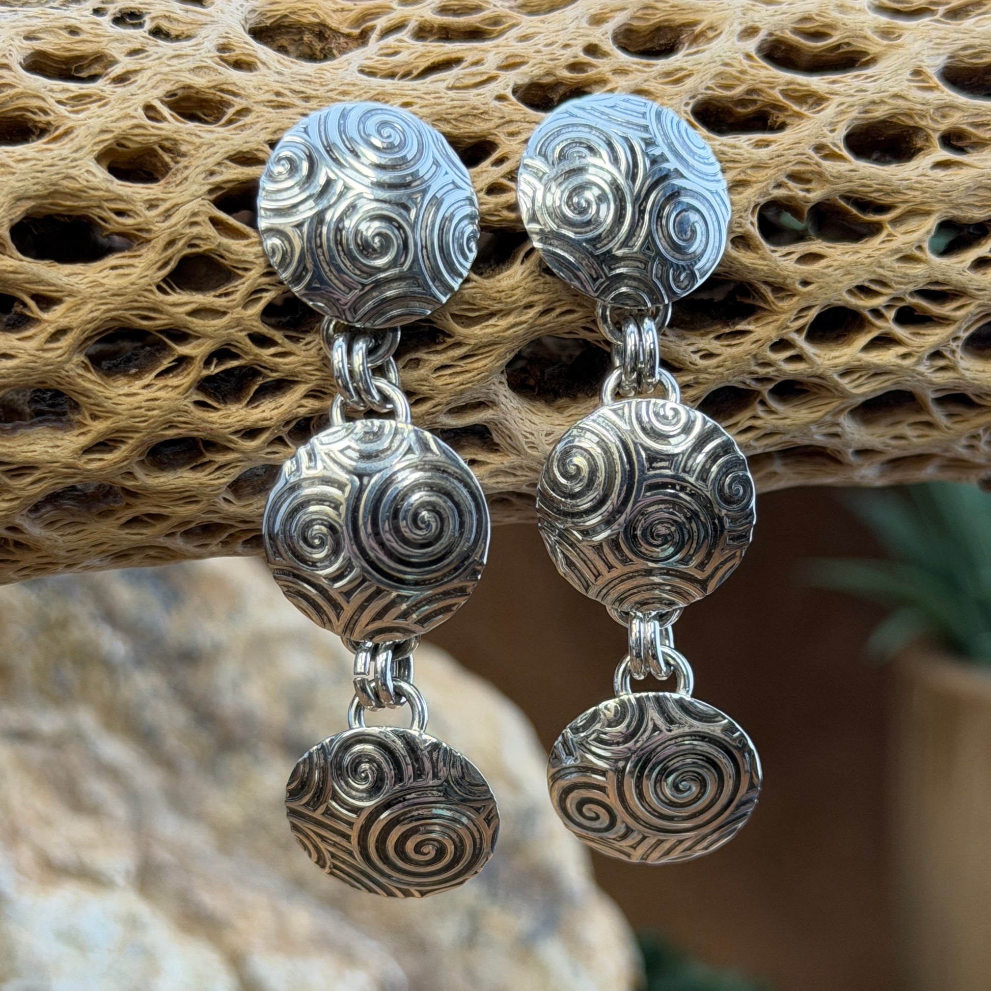 A Pair of Sterling Silver Earrings With Oxidized swirl patterns. Three graduated disks design.