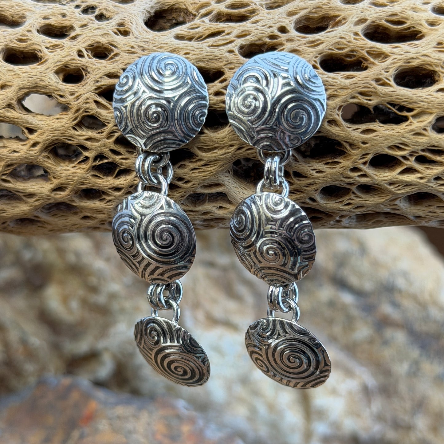 A Pair of Sterling Silver Earrings With Oxidized swirl patterns. Three graduated disks design.