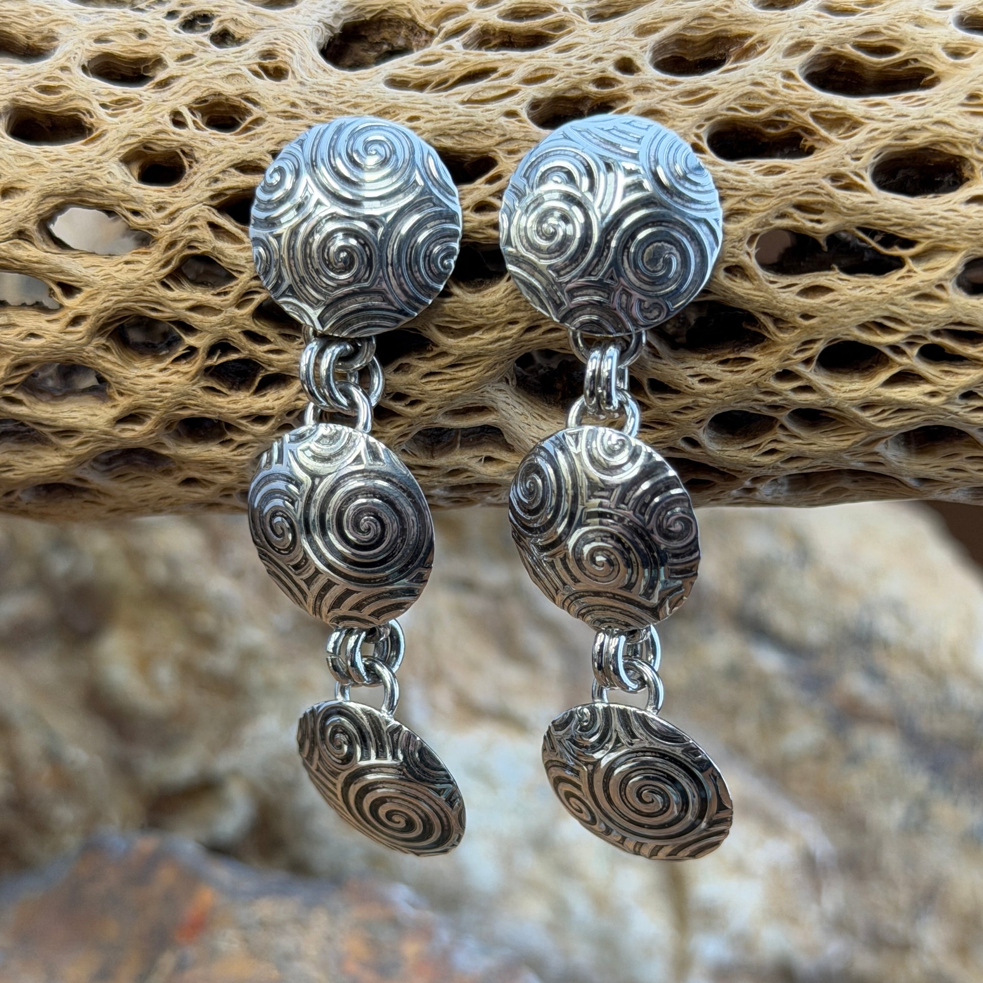 A Pair of Sterling Silver Earrings With Oxidized swirl patterns. Three graduated disks design.
