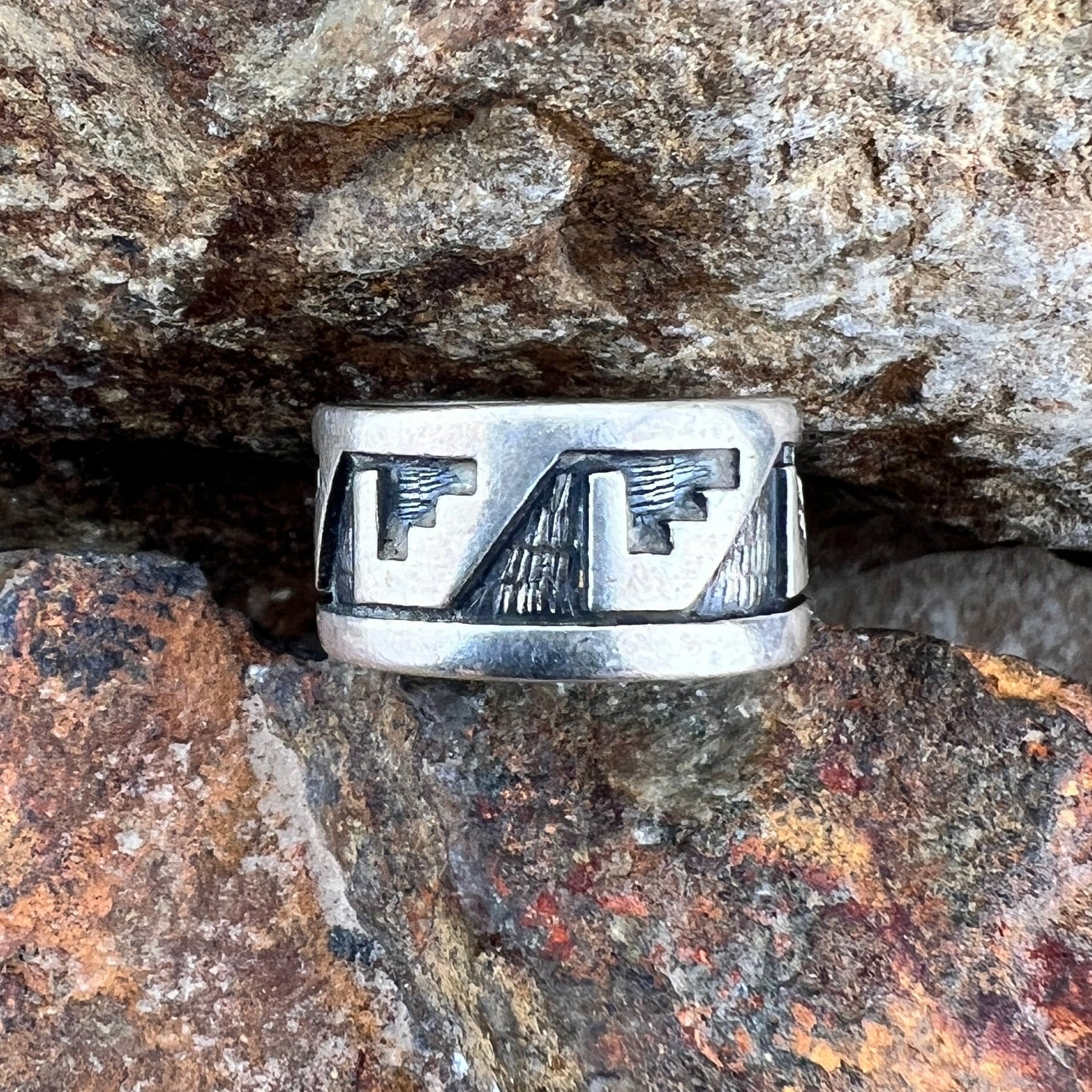 Overlayed Sterling Silver ring. Geometric Eagle--like shapes repeat themselves around the band; they are oxidized and textured. 