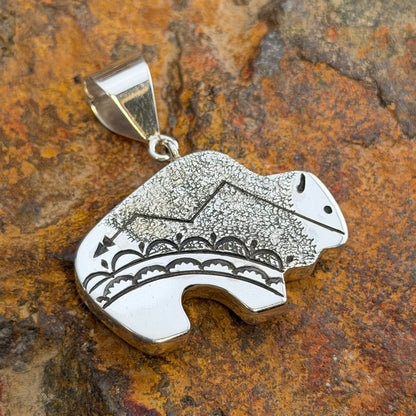 Reversible Sterling Silver Bison Pendant by Norman Woody - side one showing reticulated texture with lightning bolt and scalloped rainbow cloud band