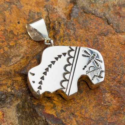Reversible Sterling Silver Bison Pendant by Norman Woody - side two showing polished surface with hand-stamped triangles, serpentine wave border, and dragonfly