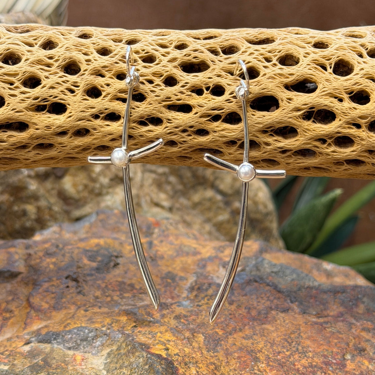 silver cross earrings with pearl in center hanging from cactus spine