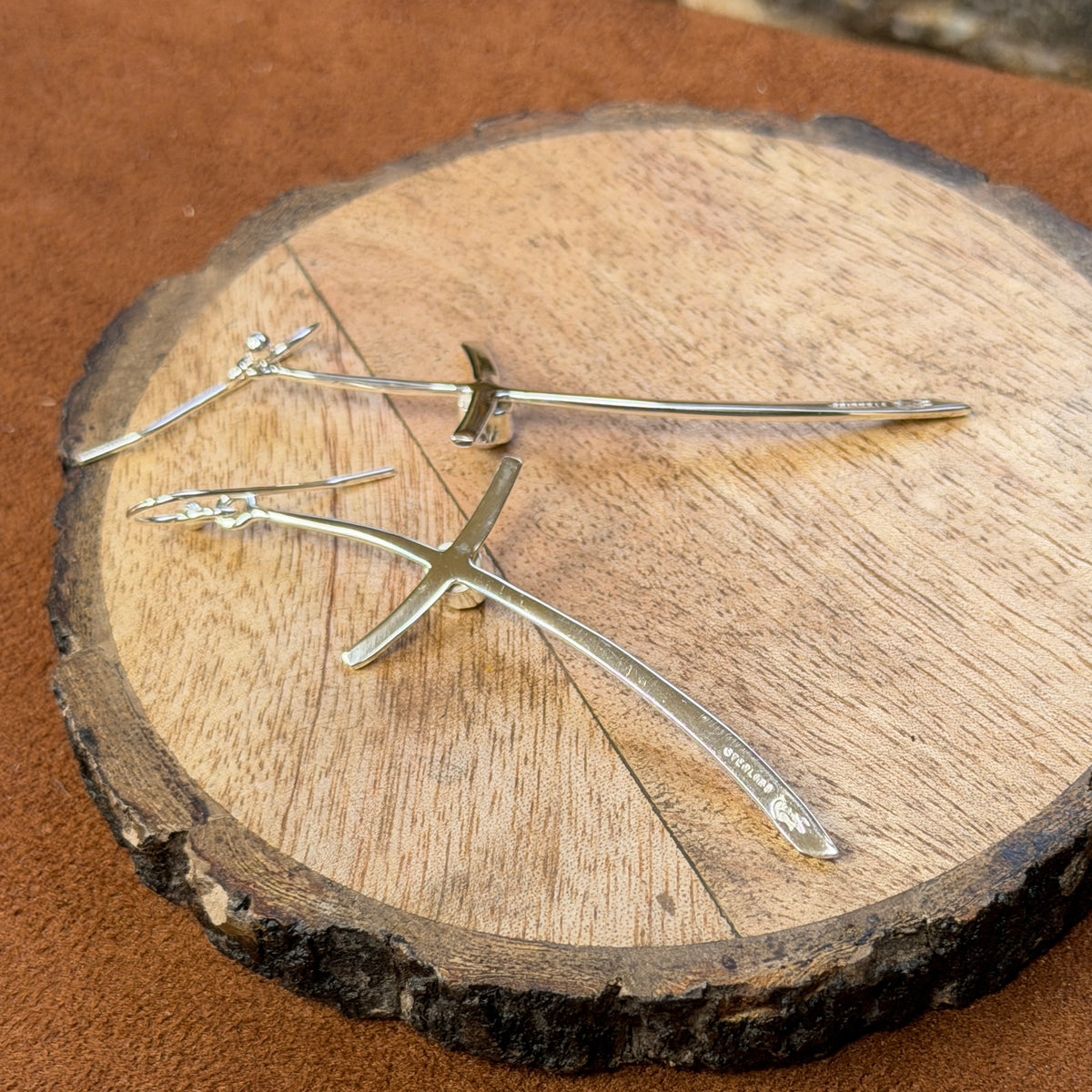 silver cross earrings displayed on wood