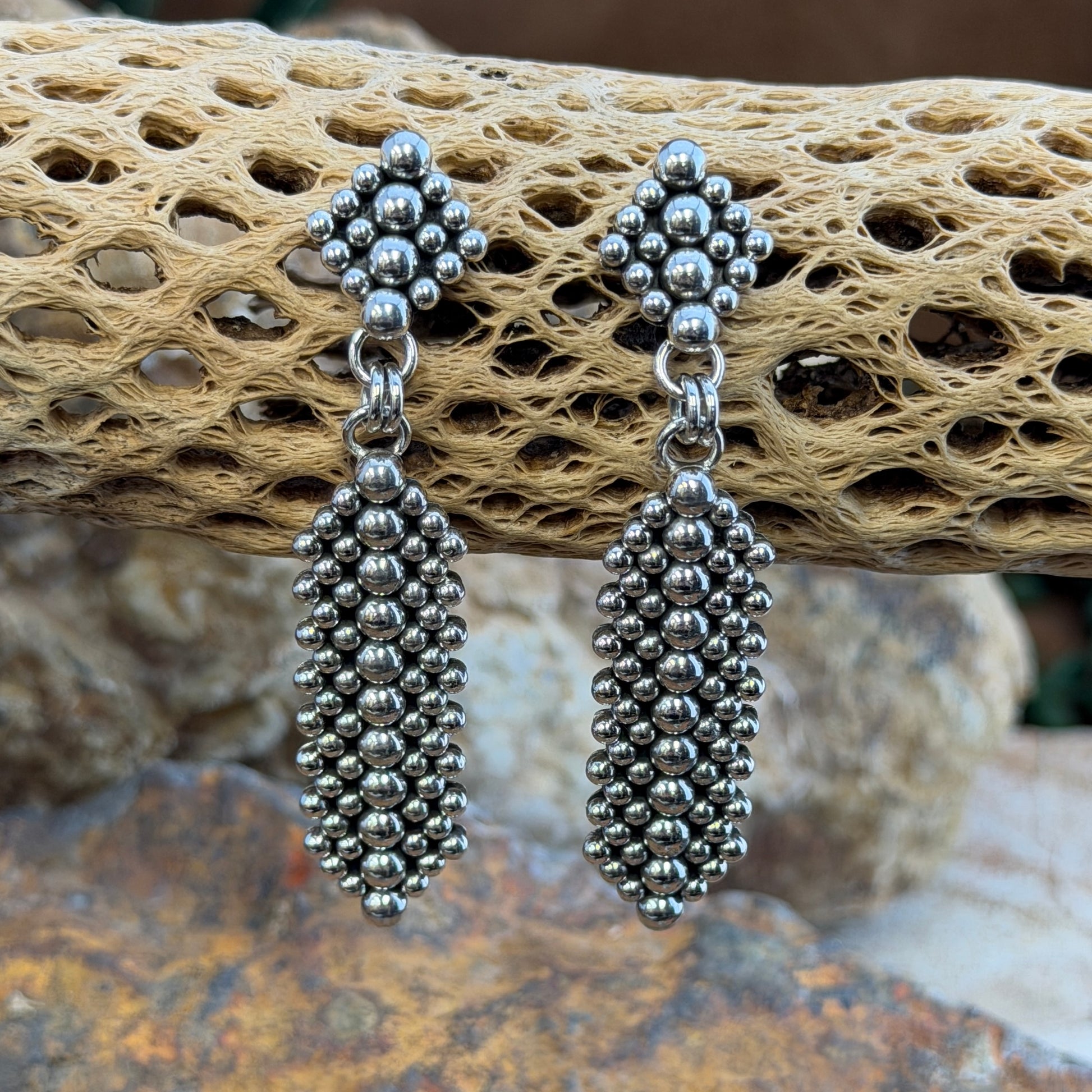 Sterling Silver Million Drop Post and Dangle Earrings by Artie Yellowhorse - styled on cholla cactus showing full length and dimensional silver sphere texture