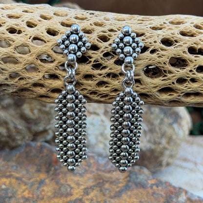 Sterling Silver Million Drop Post and Dangle Earrings by Artie Yellowhorse - styled on cholla cactus showing full length and dimensional silver sphere texture