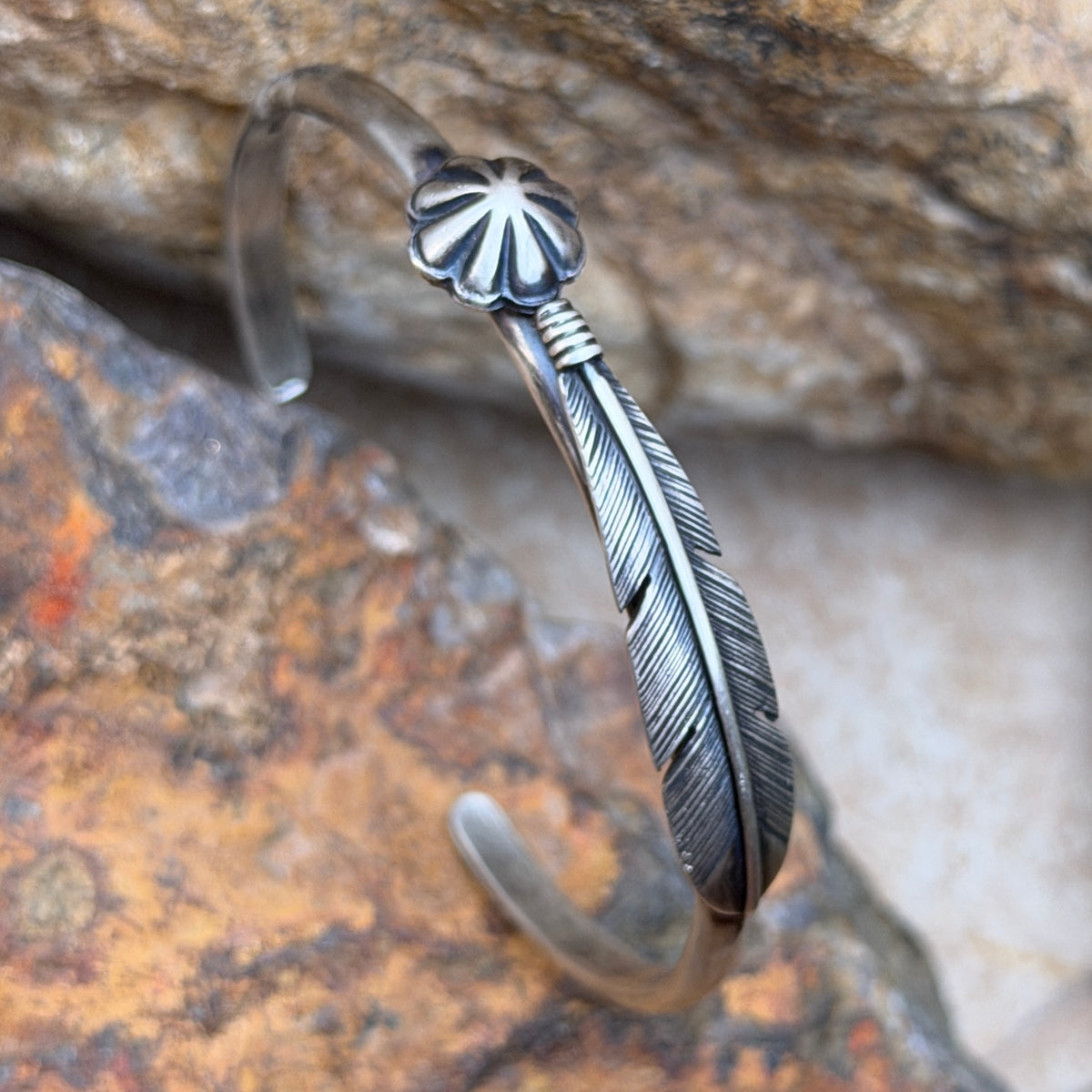 Close-up of feather engraving and floral concho on Ray Coriz silver cuff