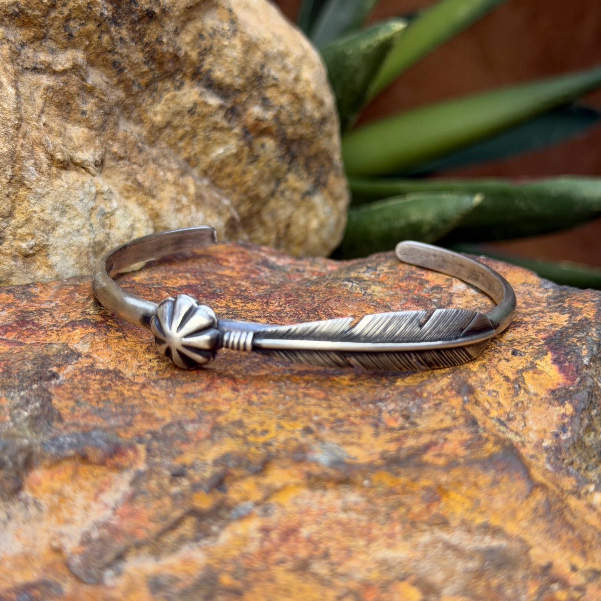 Ray Coriz sterling silver feather cuff showing raised feather shaft and scalloped concho
