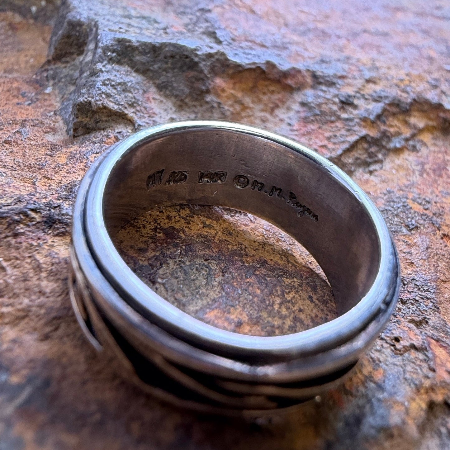 The inside of a ring featuring the hallmarks and stamps
