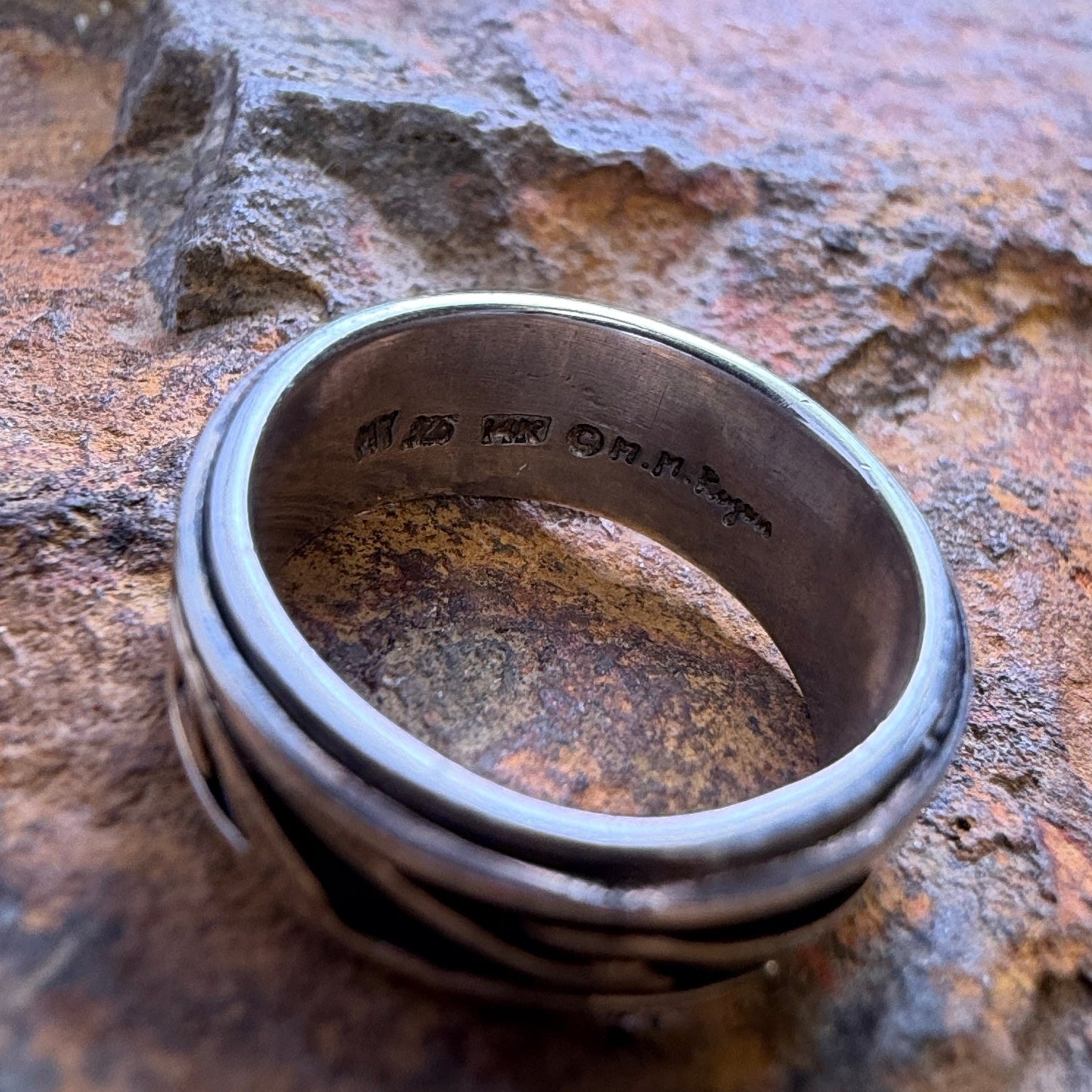 The inside of a ring featuring the hallmarks and stamps
