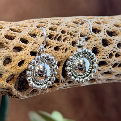 Artie Yellowhorse beaded dome earrings hanging from silver ear wires