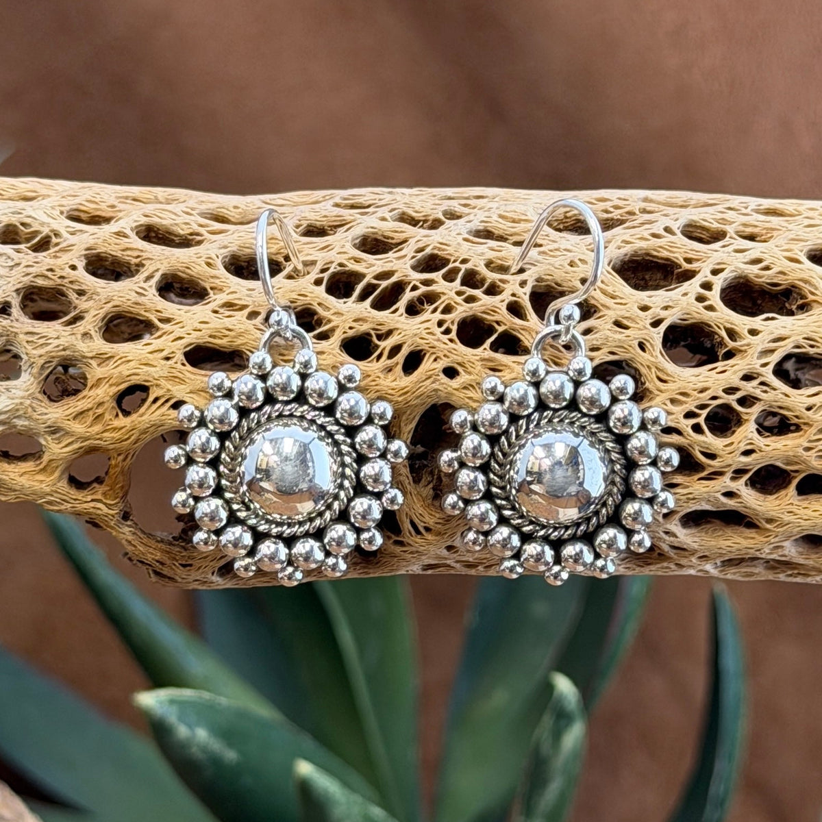 Artie Yellowhorse beaded dome earrings hanging from silver ear wires