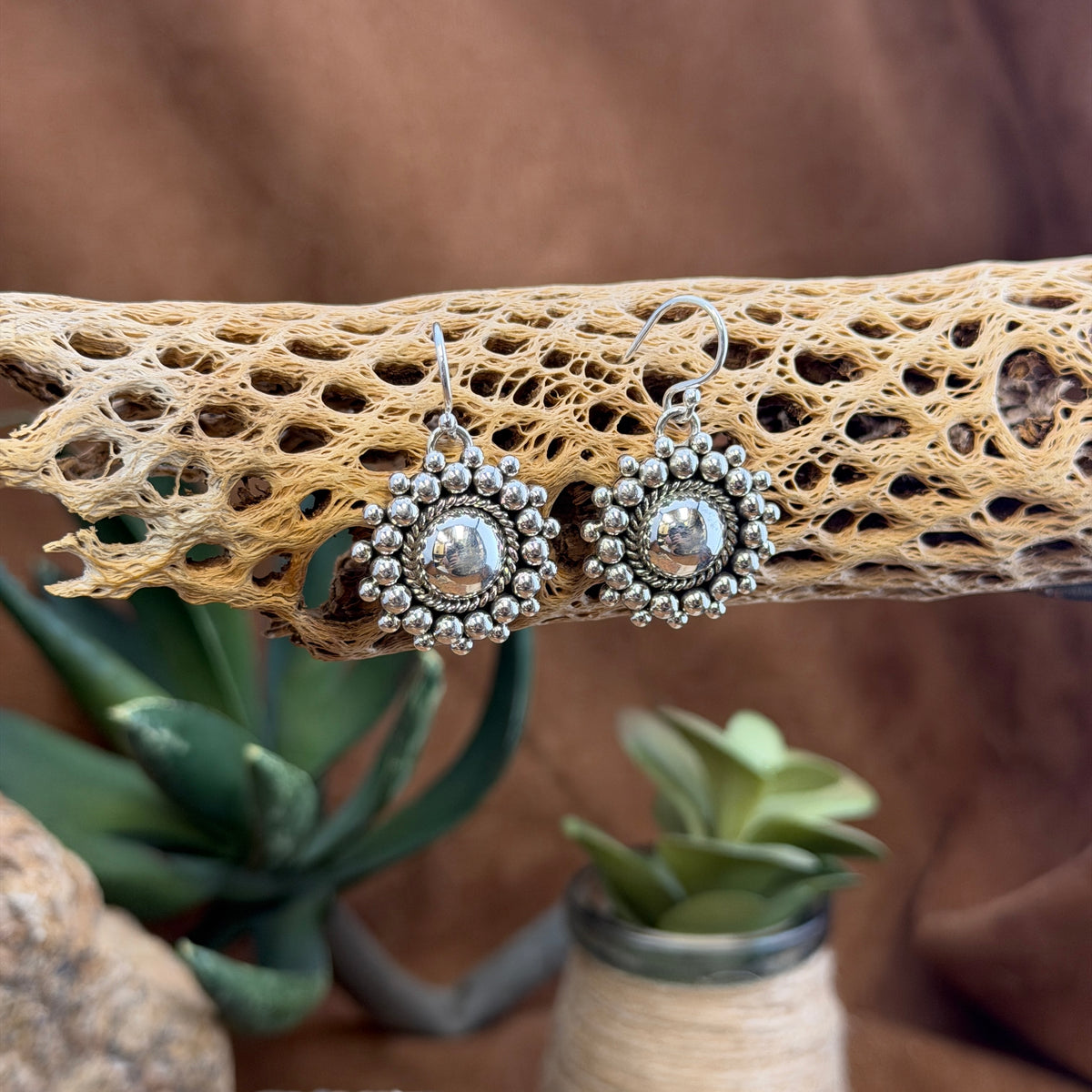 Artie Yellowhorse beaded dome earrings hanging from silver ear wires