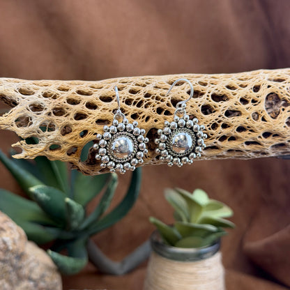 Artie Yellowhorse beaded dome earrings hanging from silver ear wires