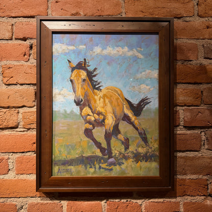 A framed painting of a galloping horse in a grassy field under a blue sky, mounted on a red brick wall.