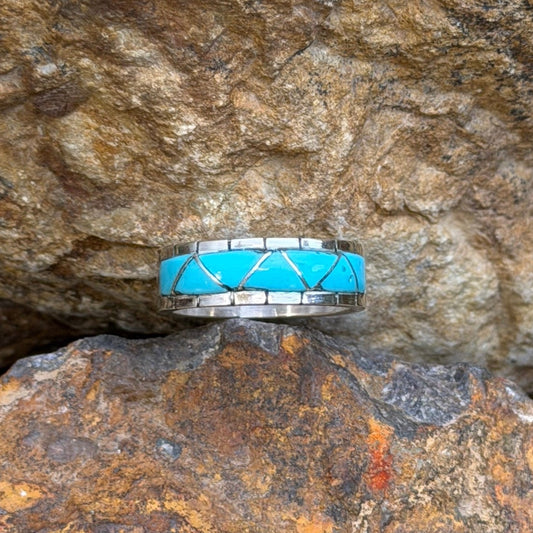 Front view of bright blue turquoise inlay and notched silver borders