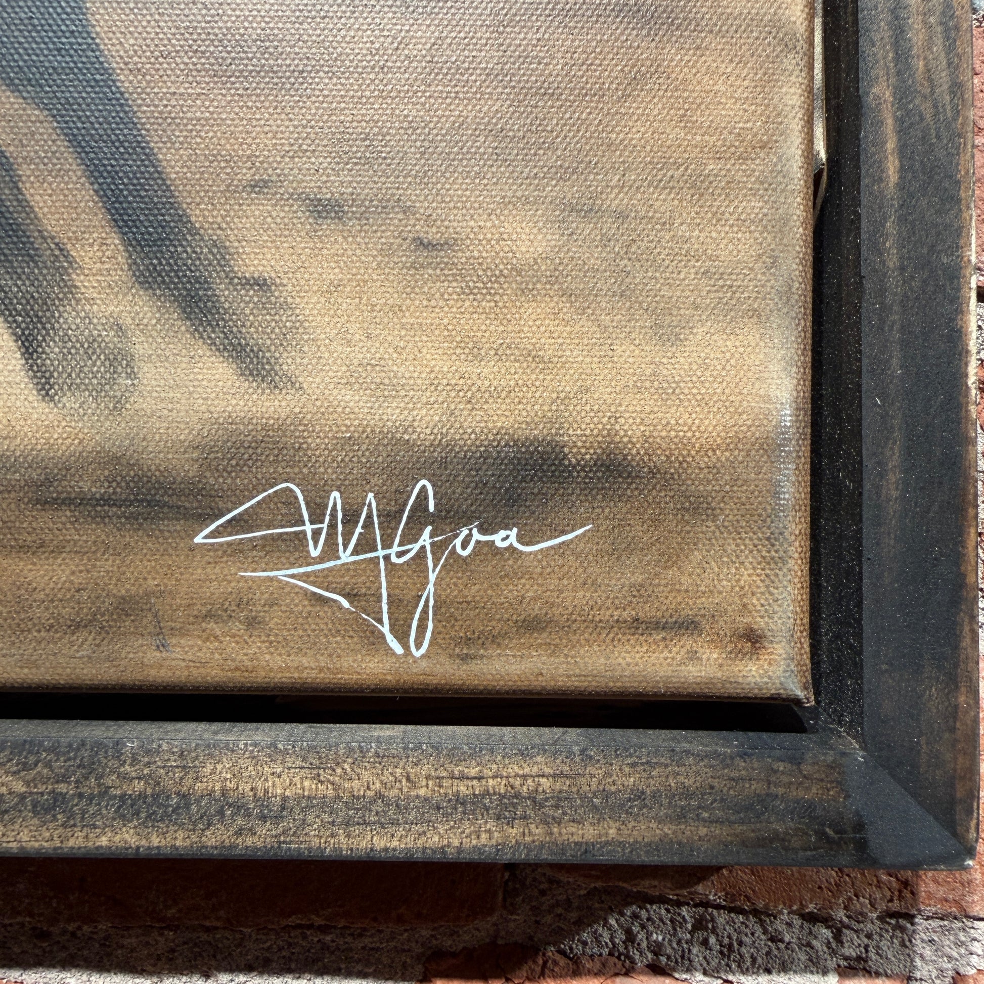 Signature on a textured surface with a wooden frame