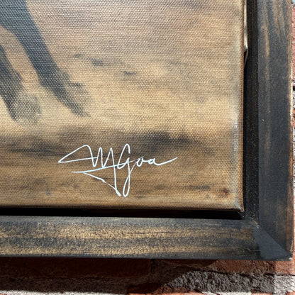 Signature on a textured surface with a wooden frame