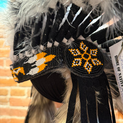 Close-up of a Native American headdress with intricate beadwork against a blurred background