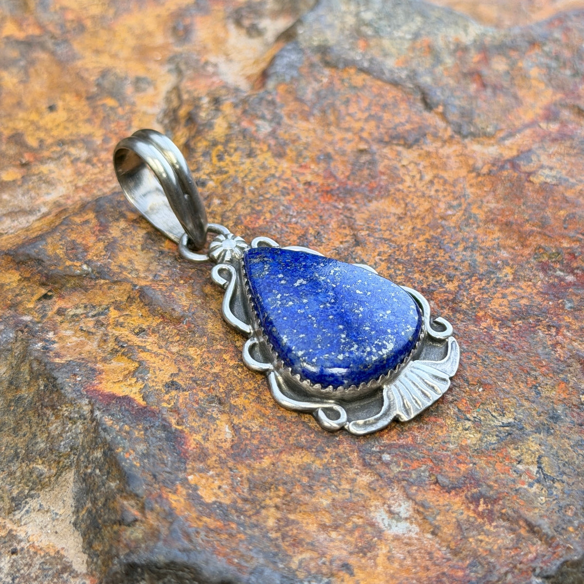 royal lapis pendant in the shape of an arrowhead decorated by silverwork by mary tso
