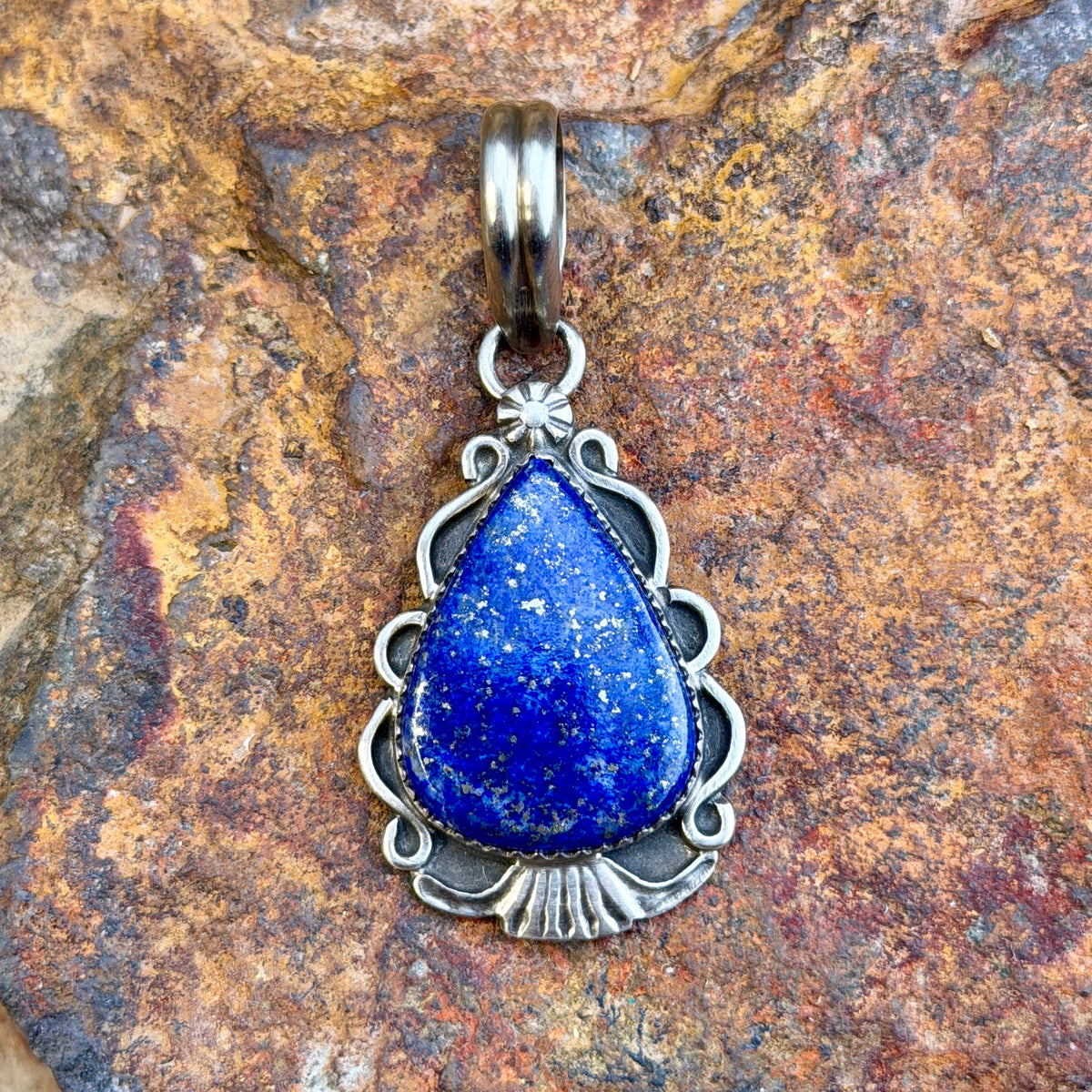 royal lapis pendant in the shape of an arrowhead decorated by silverwork by mary tso