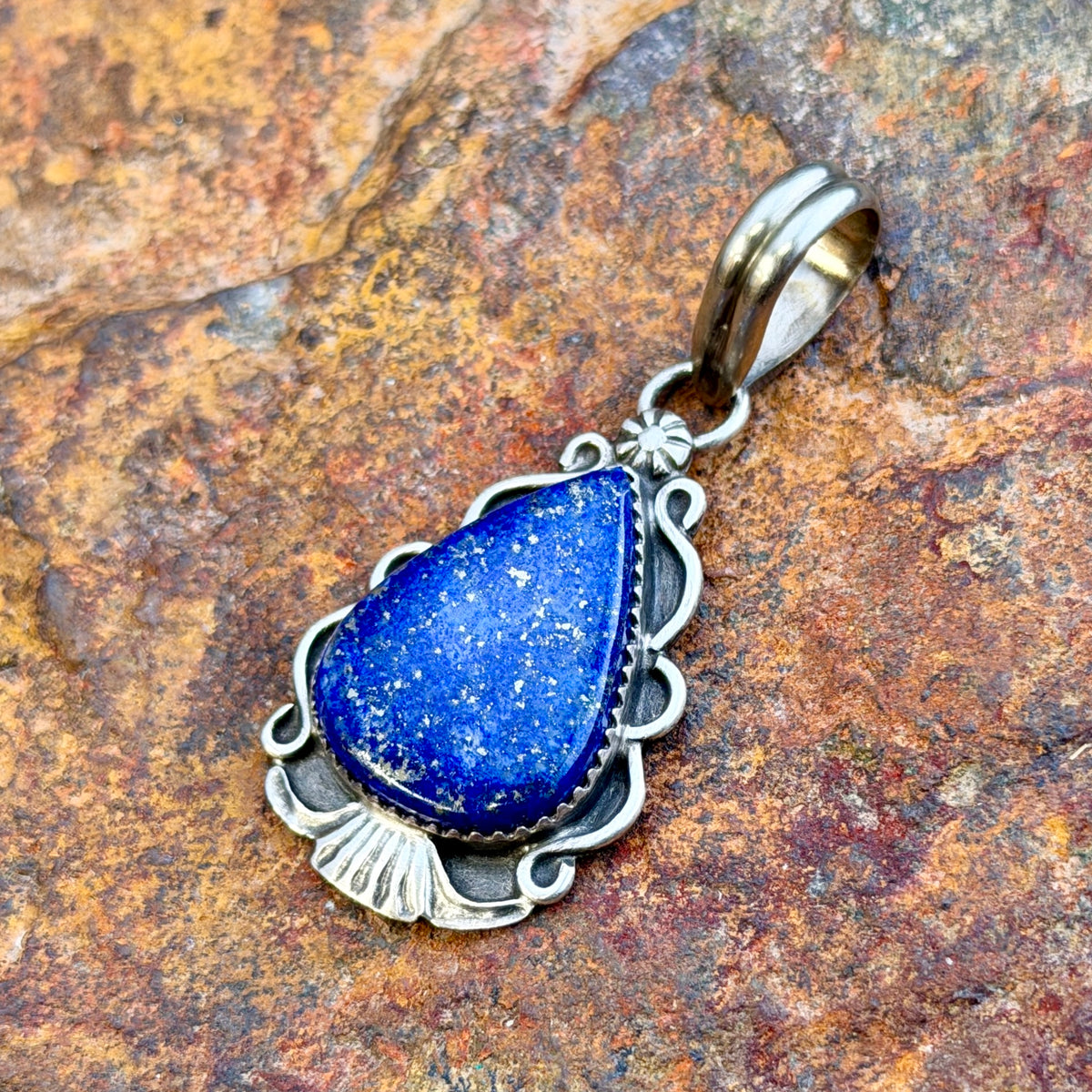 royal lapis pendant in the shape of an arrowhead decorated by silverwork by mary tso