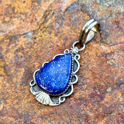 royal lapis pendant in the shape of an arrowhead decorated by silverwork by mary tso