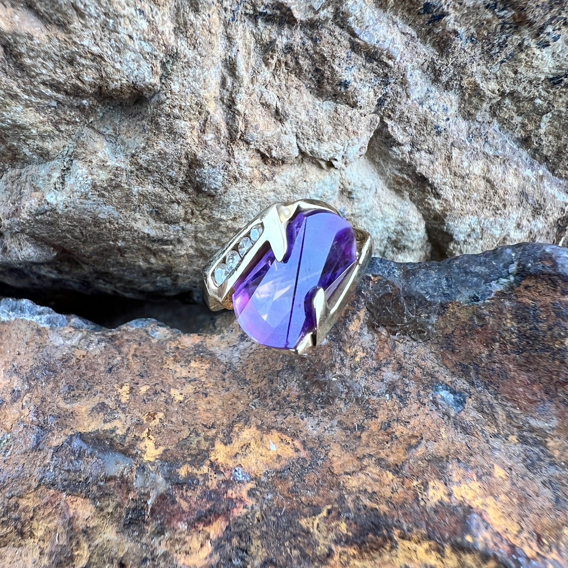 Large amethyst ring with diamonds on a gold band.