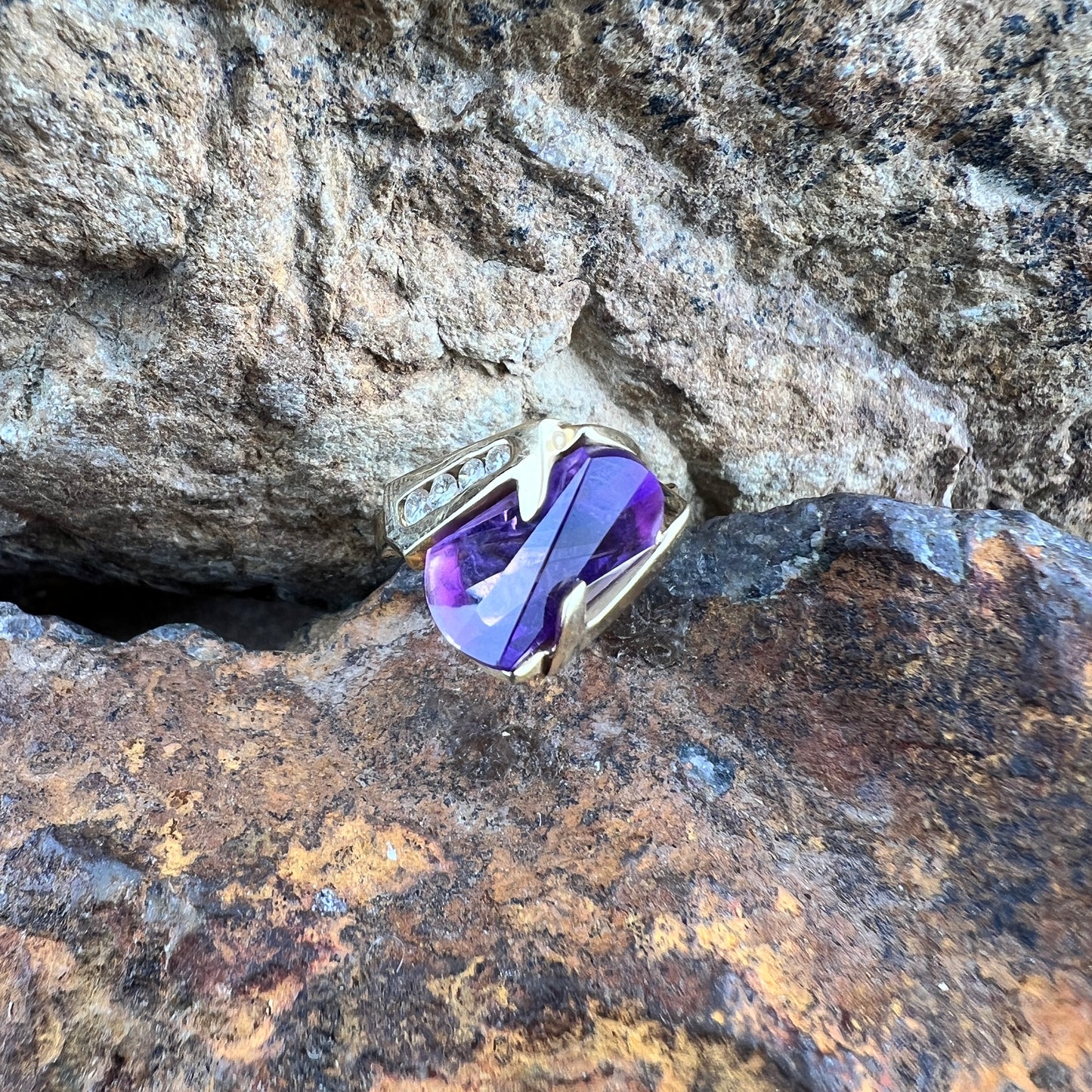 Large amethyst ring with diamonds on a gold band.