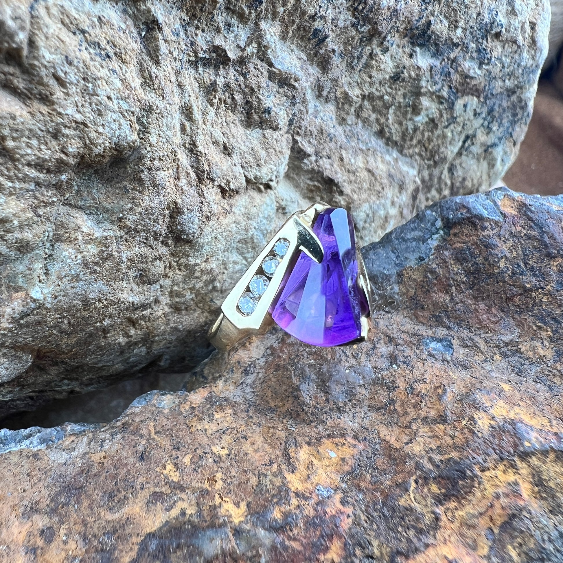 Large amethyst ring with diamonds on a gold band.