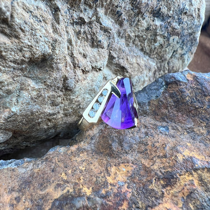 Large amethyst ring with diamonds on a gold band.