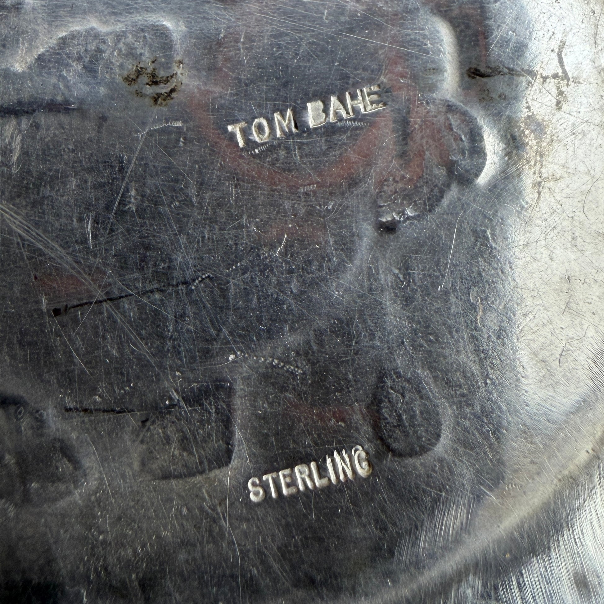 Close-up of the sterling silver belt buckle back with 'TOM BAHE' and 'STERLING' engrave
