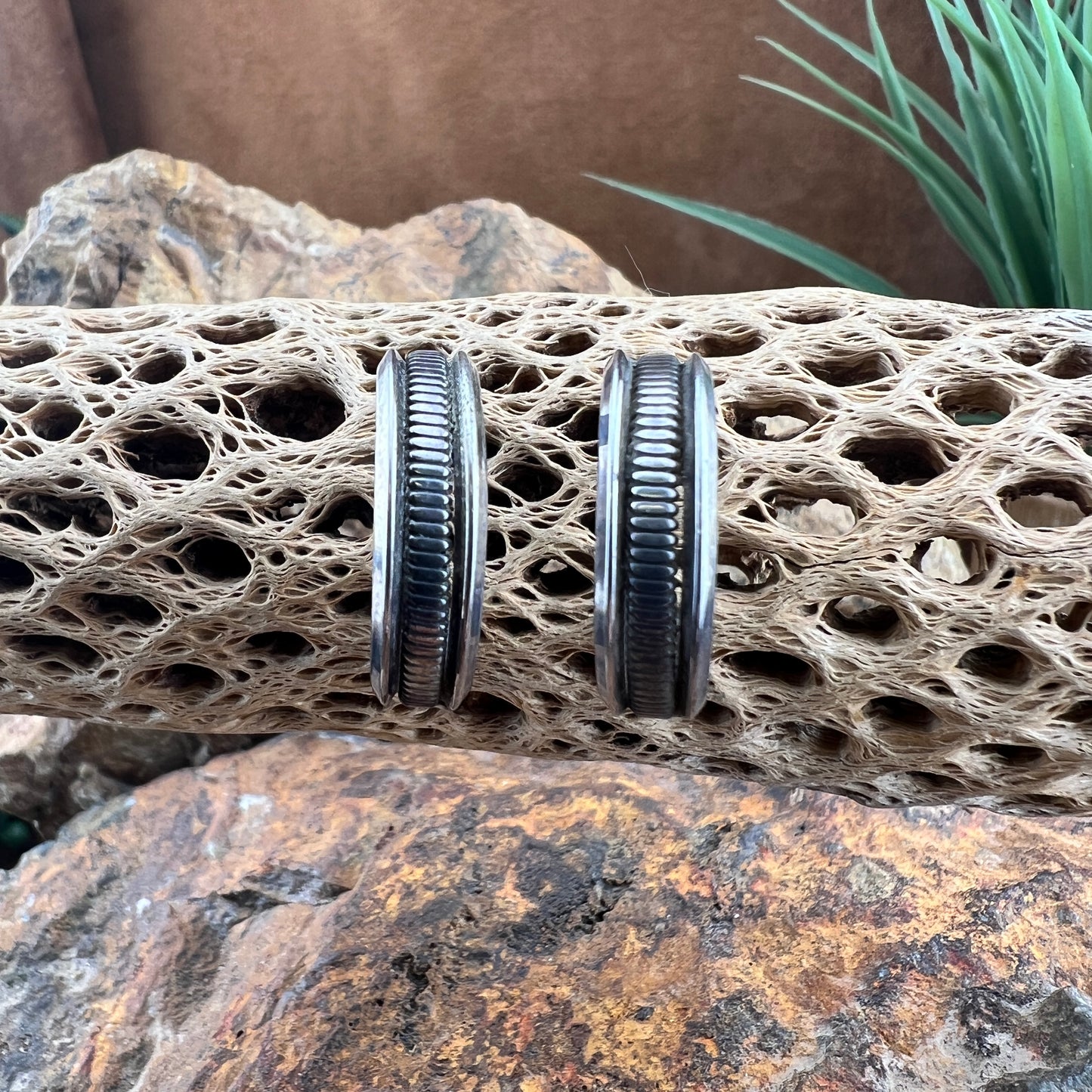 sterling silver half-hoop earrings featuring a deeply oxidized ribbed center band flanked by smooth, polished rims.