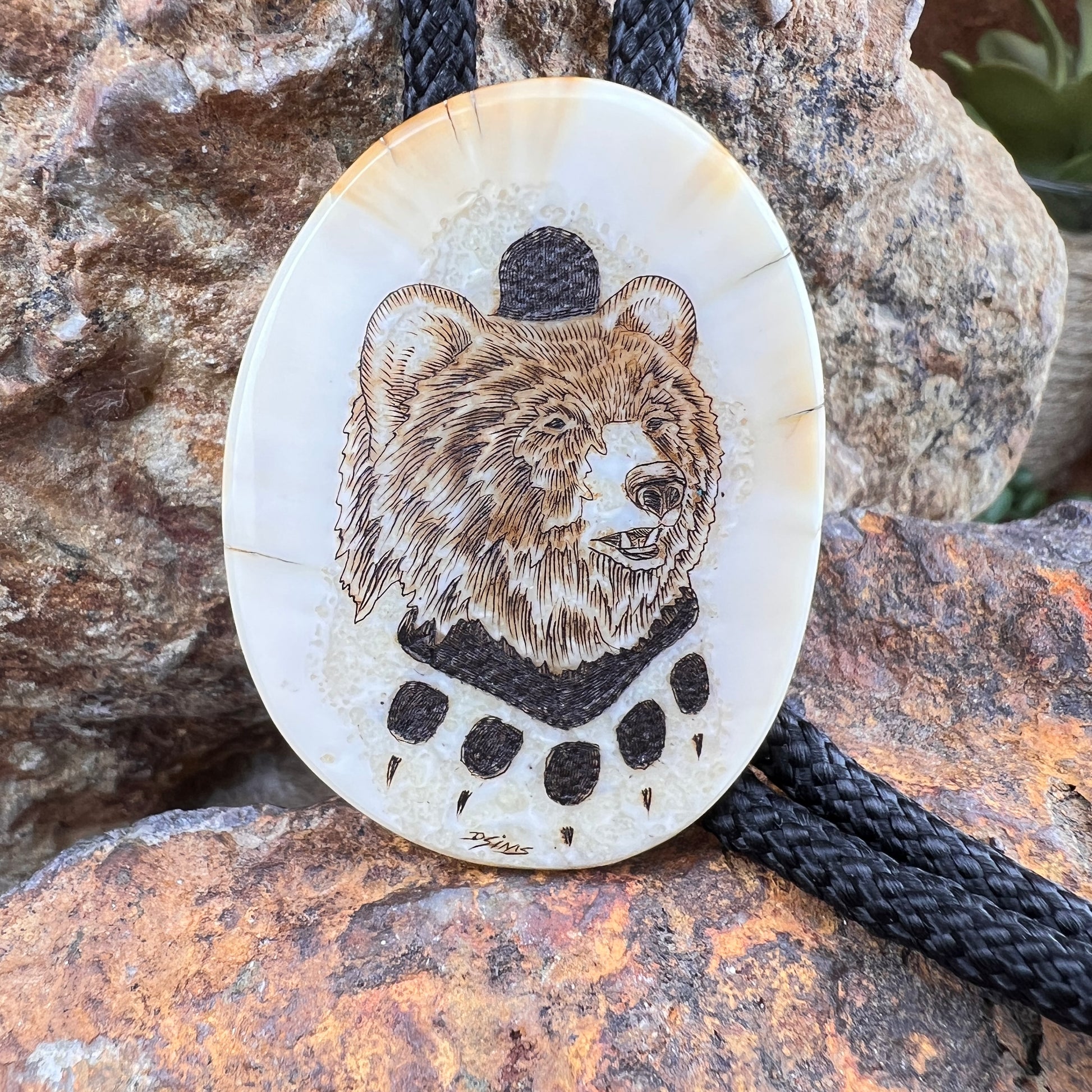 Round pendant with bear design on a stone surface