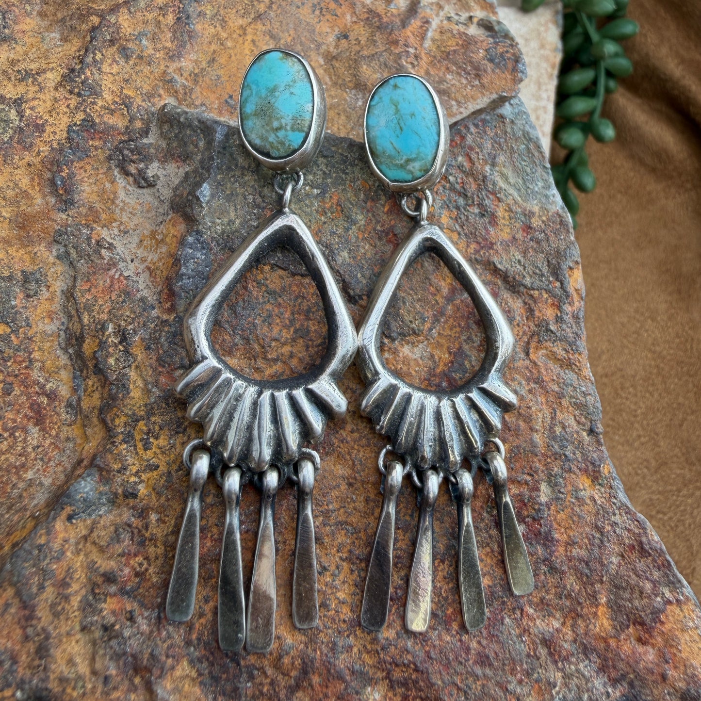 Turquoise Sterling Silver Chandelier Post Earrings by Mike Platero - flat lay on rock showing full front view with radiating ridges and five hammered silver drops
