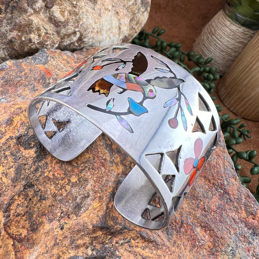 Decorative metal bracelet with cut-out designs on a stone surface