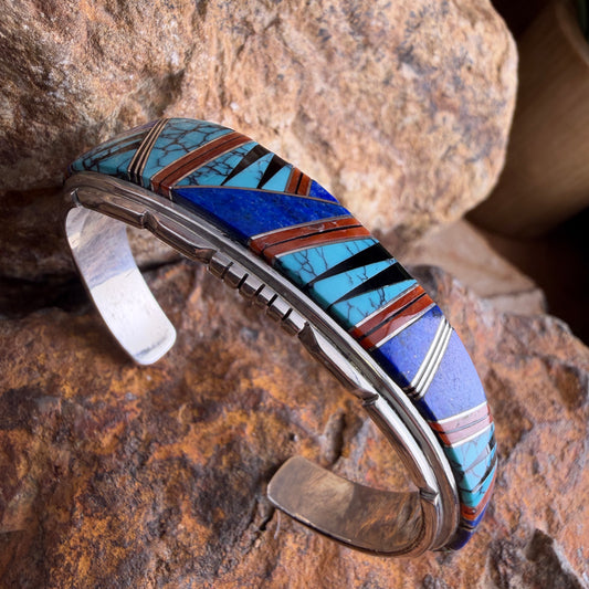 Multicolored cuff bracelet on a textured stone surface