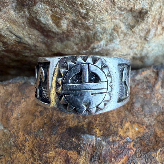 Silver ring with intricate design on a stone surface