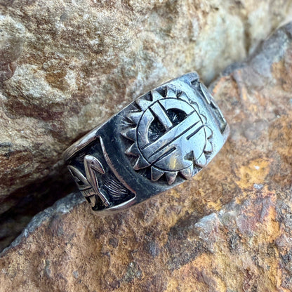 Silver ring with intricate design on a stone surface