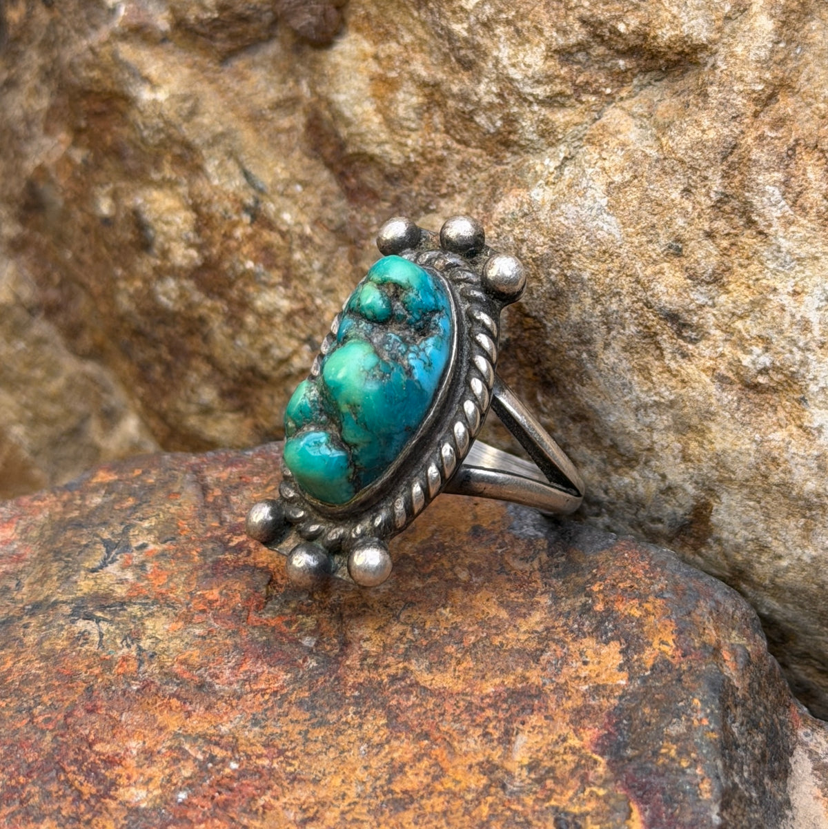 Angled view of vintage oval turquoise ring with silver bead accents