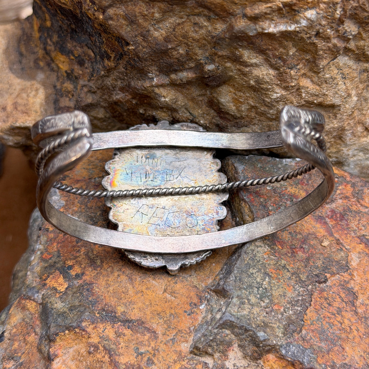 Side view of vintage turquoise cuff showing stamped outer rails and twisted-wire center
