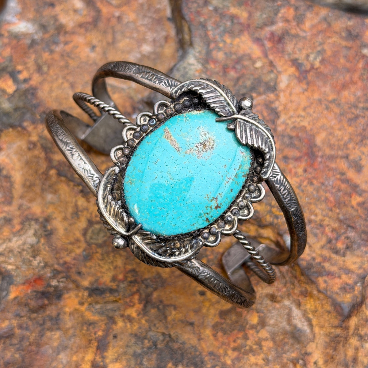 Front view of vintage sterling silver turquoise cuff with silver leaf details and RECO hallmark