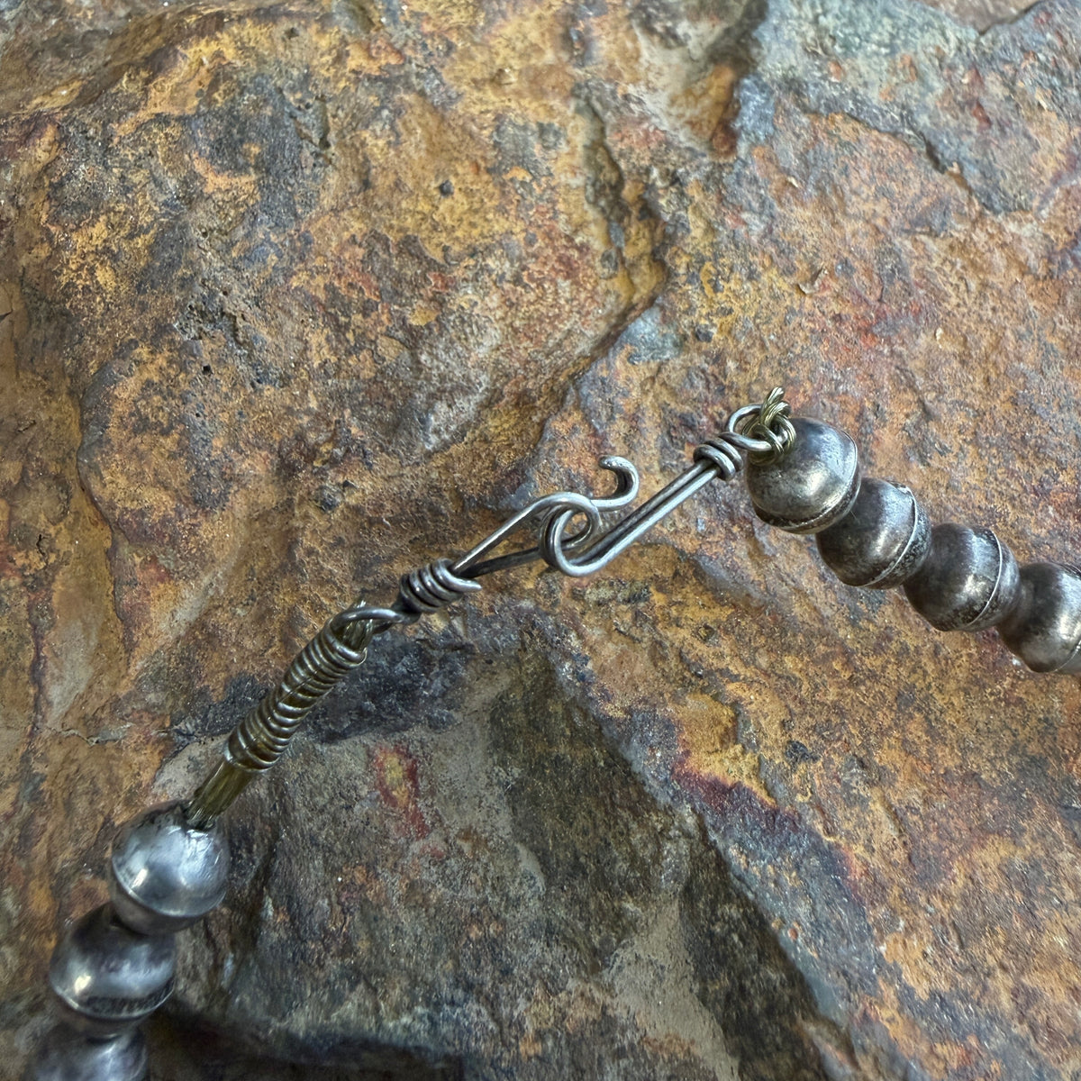 Hook in eye clasp closure photographed on a rock surface. 