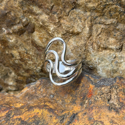 Angled view of Ray Coriz sterling silver smooth wave ring showing open spaces between the bands